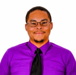 Portrait of Ricky Adams, Web Developer in a purple shirt and tie